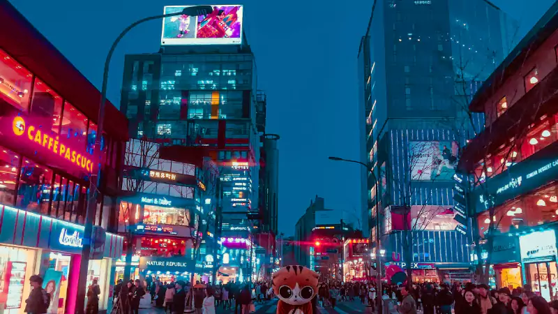 Night street in Seoul with neon signs and people walking under bright city lights
